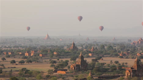 balloons fly above the stone temple on the plains of pagan bagan burma myanmar