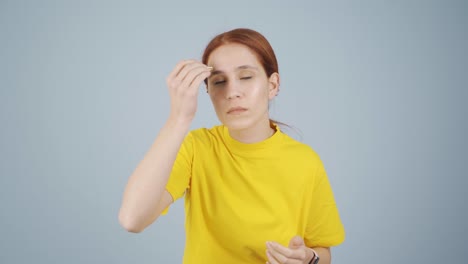 woman plucking her eyebrows with tweezers. facial care.