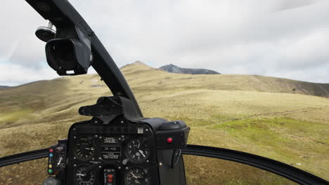 pov helicopter cockpit flying over majestic meadows on the side of the mountain