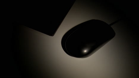 hand holding computer mouse in dark room
