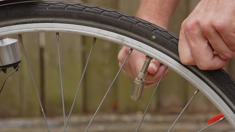 hands using air compressor to inflate bicycle tire