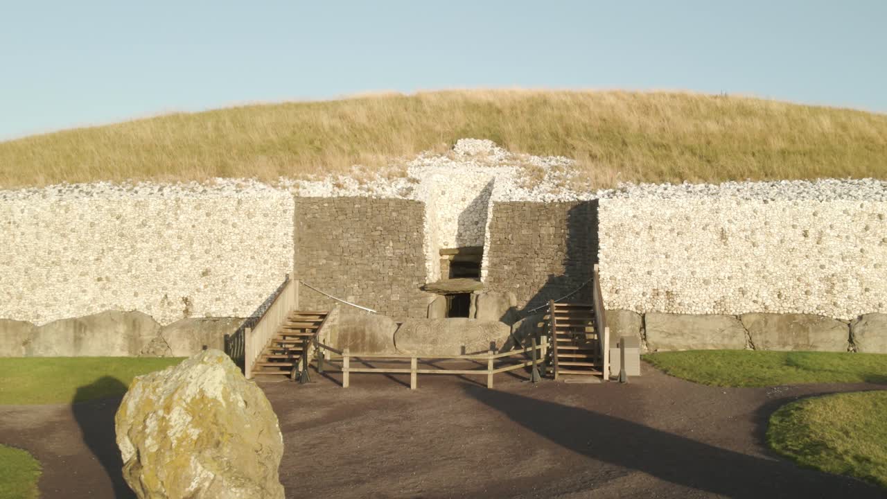 Entrance Passage And Entrance Stone Of Newgrange During Sunrise In County Meath, Ireland. - aerial forward shot