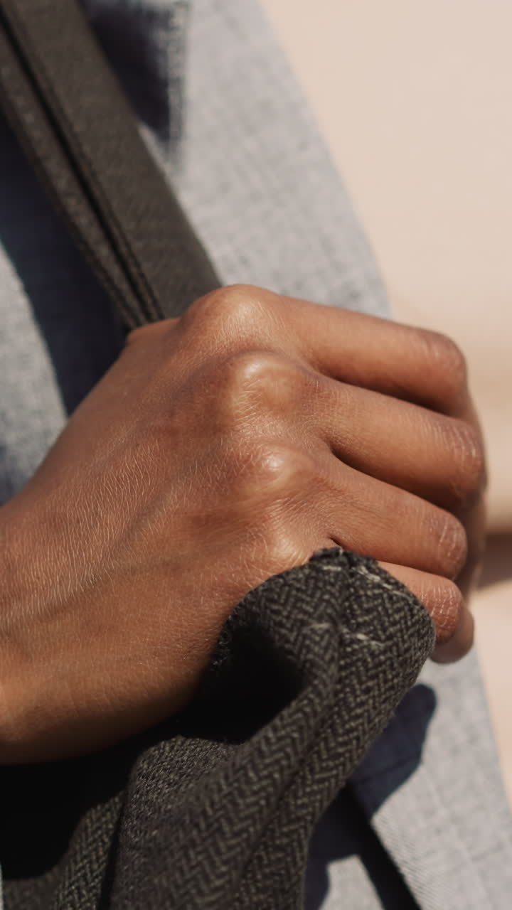 African-American woman in casual clothes with handbag walks along street closeup slow motion. Garment and accessory for everyday. Urban fashion