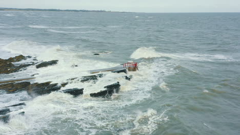 暴風雨期間海浪撞擊海岸線的岩石的空中圖像