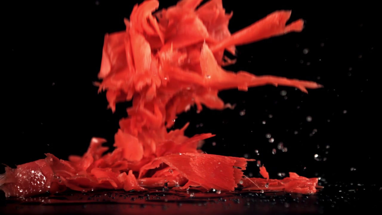 Slow Motion of Red Pickled Ginger Splashing on Black Background