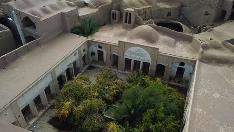 gran hermosa casa en el desierto con diseño y decoración tiene un montón de viejas puertas de madera antiguas árbol de granada verde y adobe material para hacer casa de arcilla en clima caliente concepto de eco lodge resort iran