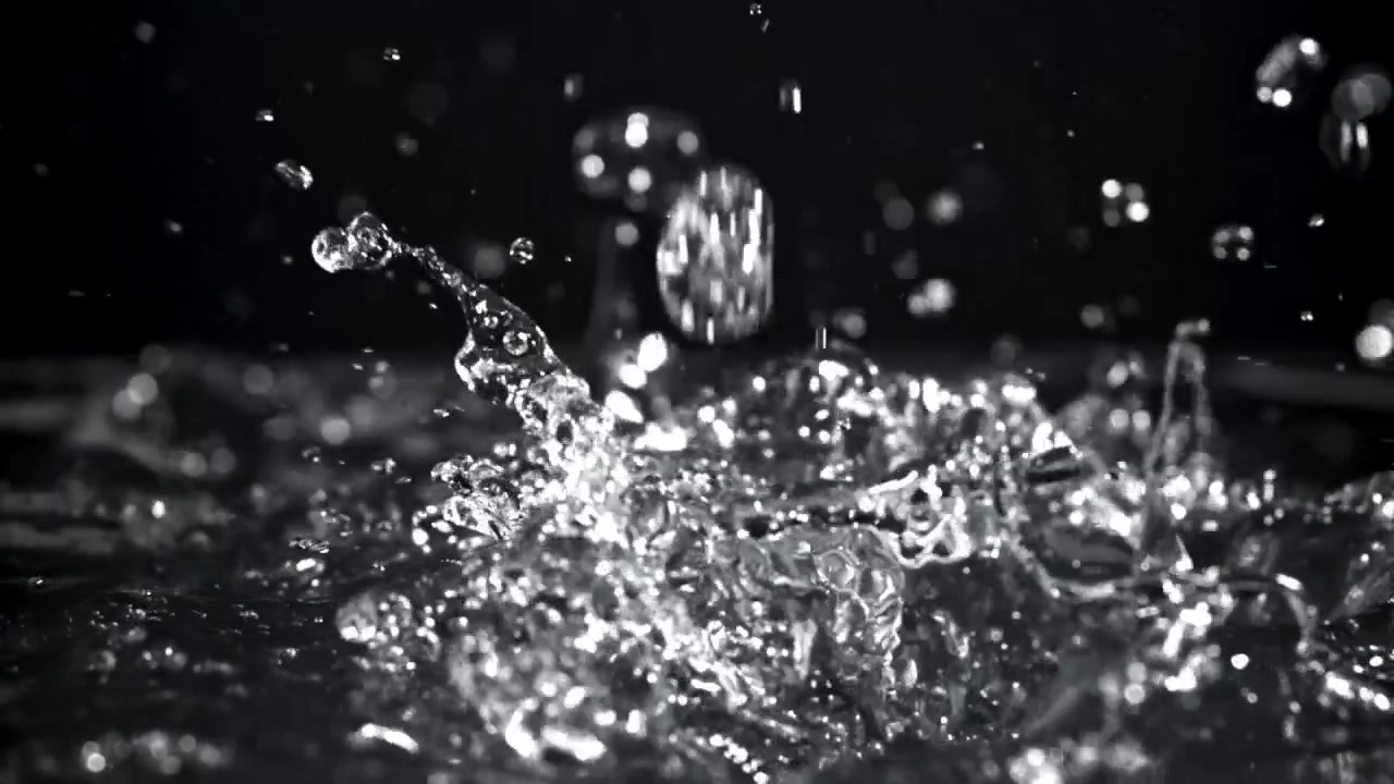 Slow Motion Water Droplets Splashing on a Dark Surface