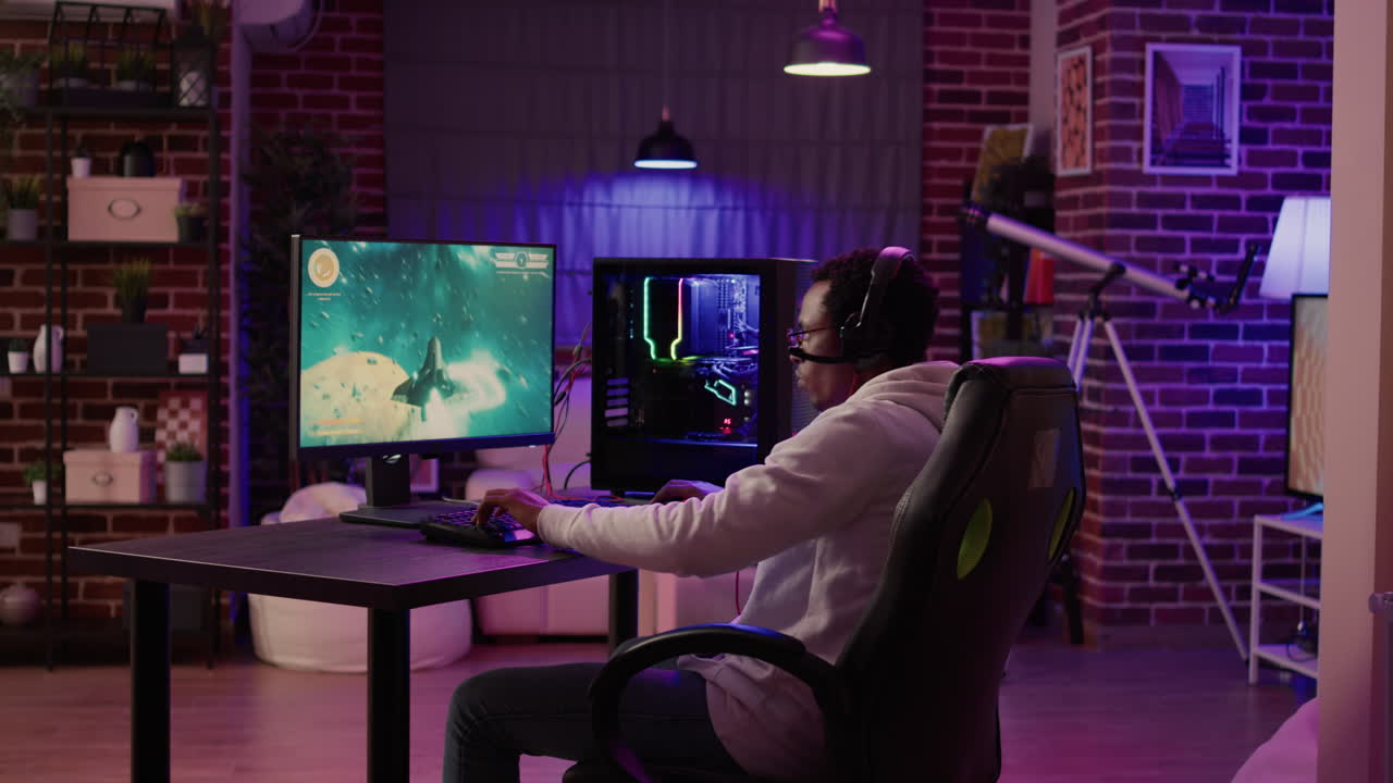 African american man playing fast paced multiplayer space shooter using pc gaming setup having a good time