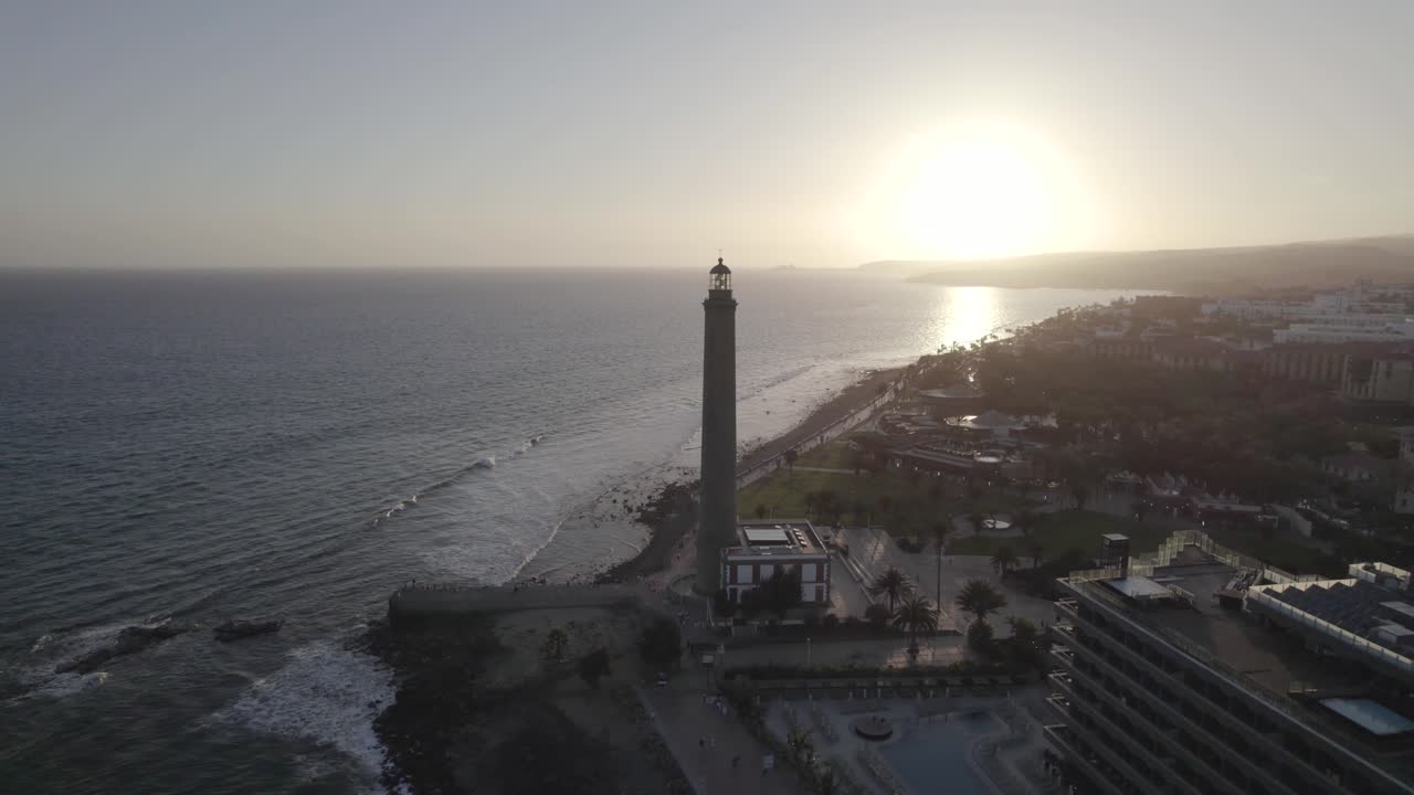 vista aérea del histórico faro de maspalomas en las islas canarias, fondo de puesta de sol