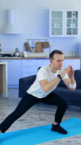 man on fitness mat at home. strong athletic fit man doing exercises at home
