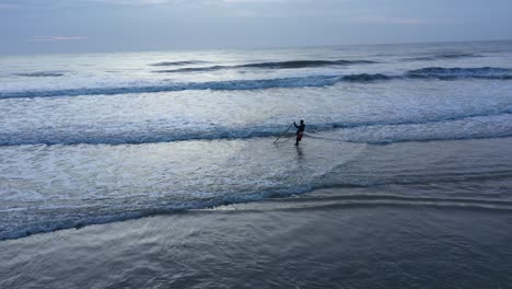 Vista-Aérea-De-Un-Pescador-Recogiendo-Almejas-En-Una-Playa-En-El-Sudeste-Asiático