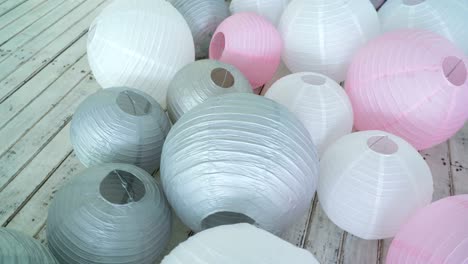 colorful white pink gray paper lanterns set on floor.