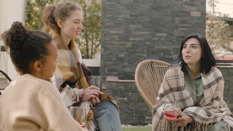 a nice multicultural group of three girlfriends conversing and drinking wine