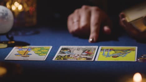 primer plano de una mujer dando una lectura de tarot en la mesa a la luz de las velas 15