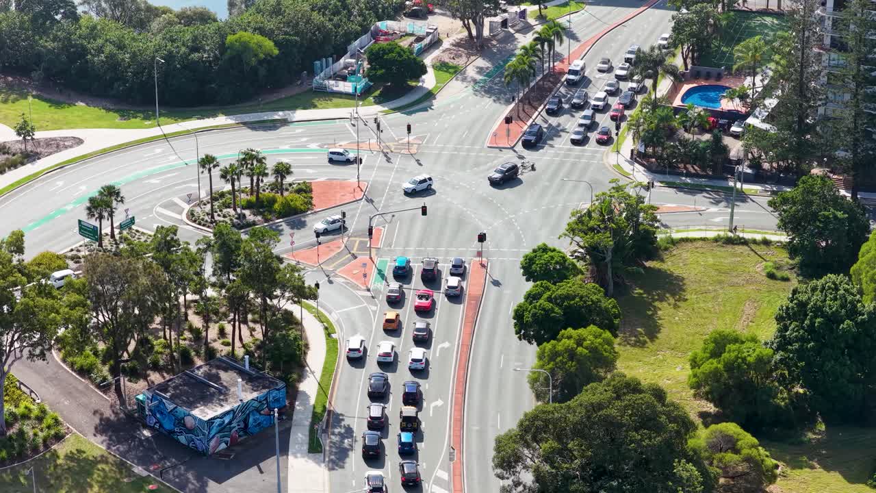 Aerial view of cars navigating a bustling intersection in Gold Coast under bright daylight