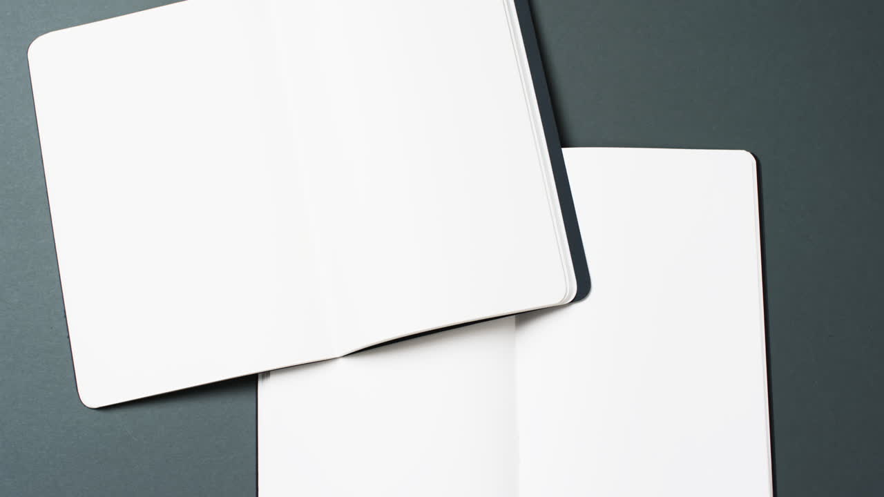 Video of books with white blank pages and copy space on black background