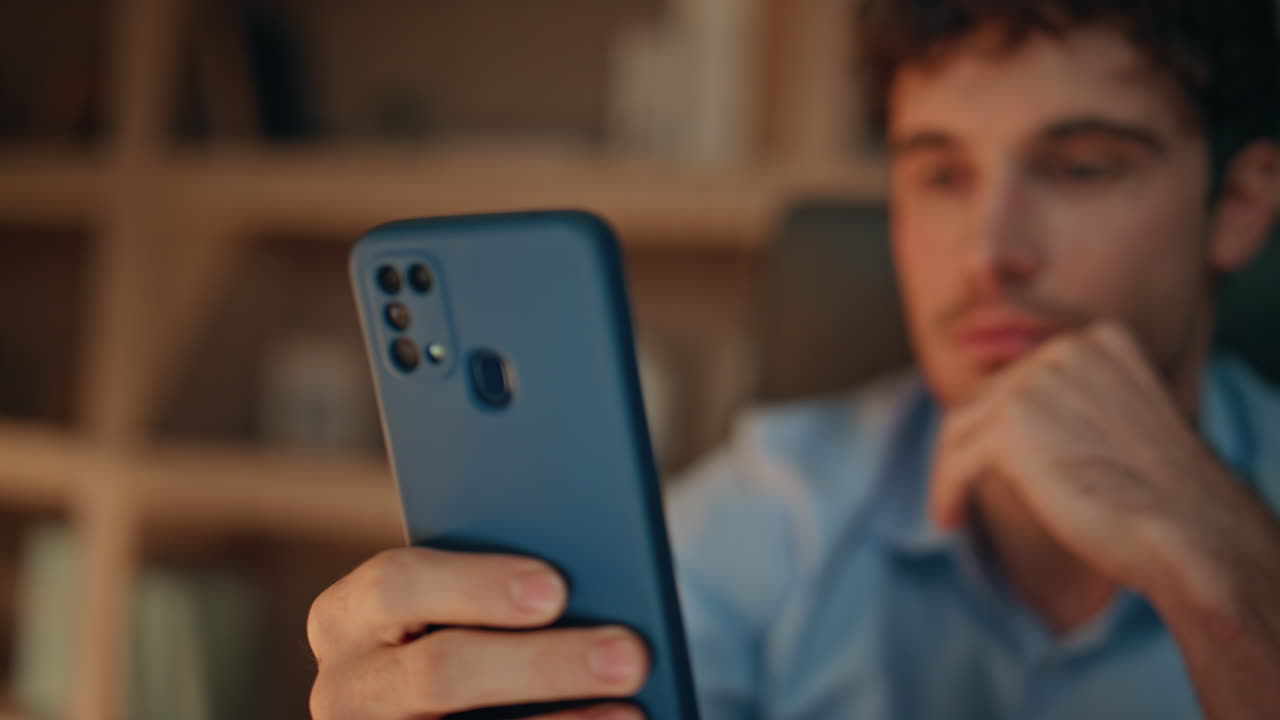 Freelancer hands holding cell phone in dark home close up. Serious businessman