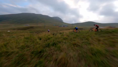 spectacular drone flight following group of mountain biker riding downhill the mountain path