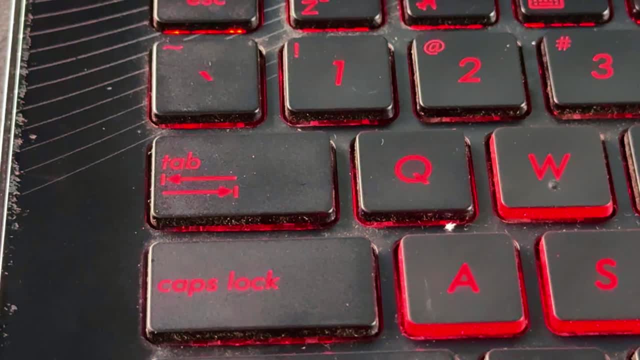 Human finger interacting with backlit keyboard in "tab" button, representing technology, online work, and productivity