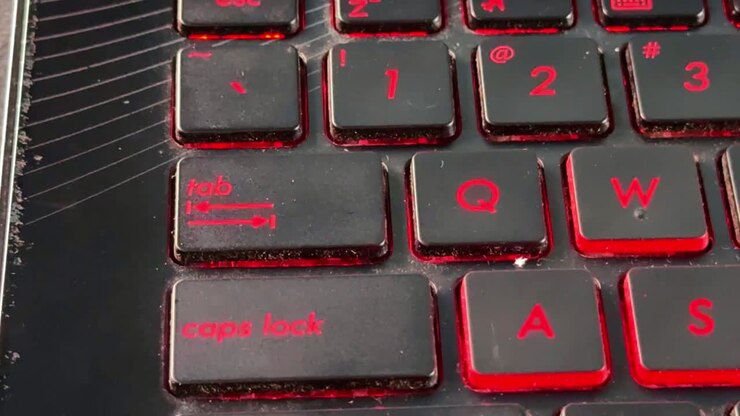 Human finger interacting with backlit keyboard in "tab" button, representing technology, online work, and productivity