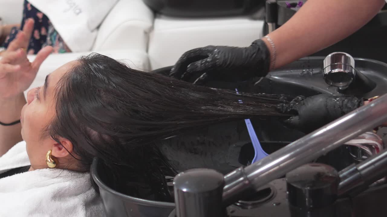 Latin Woman receiving Restorative shampoo session for healthy, vibrant hair