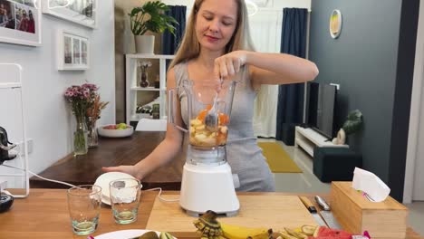 woman making a fruit smoothie