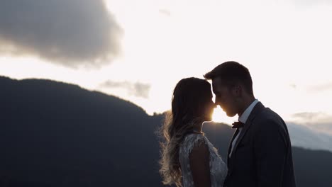 encantadores jóvenes recién casados novia novio abrazándose en la ladera de la montaña, tomándose de la mano, pareja de bodas familia