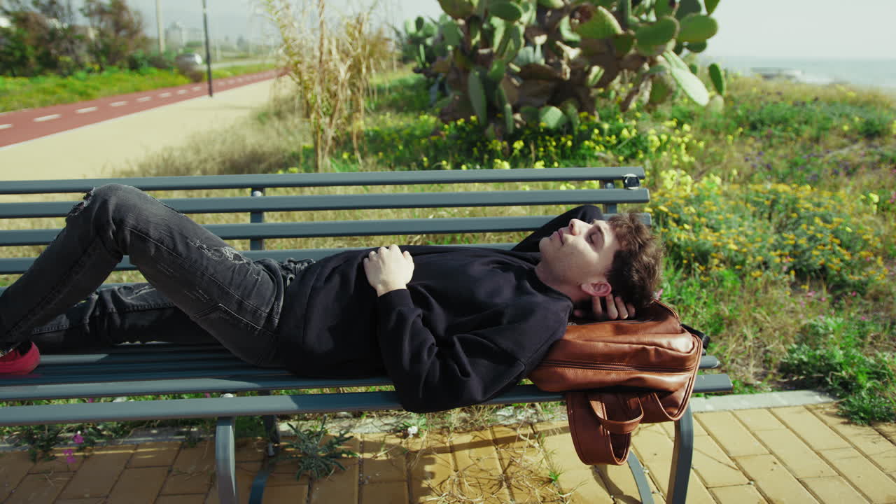 Man Relaxing In The Nature Near The Sea On A Bench