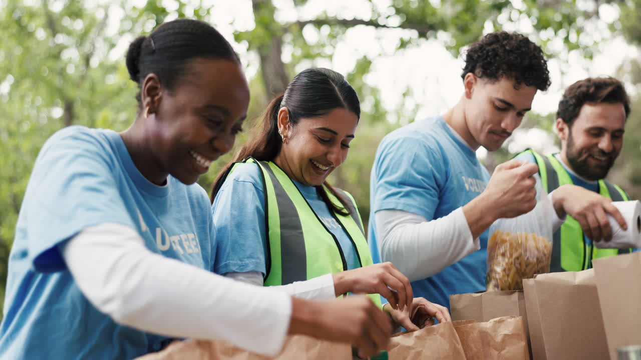 Voluntários Alegres Fazendo High-Five e Embalando Doações de Alimentos ao Ar Livre