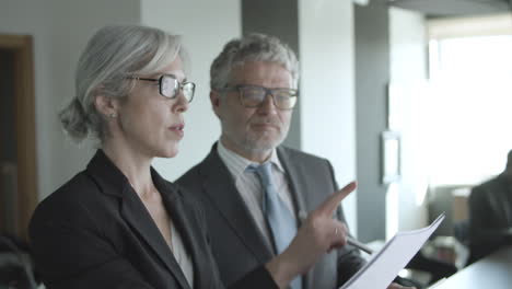 two focused business leaders reading and analyzing documents