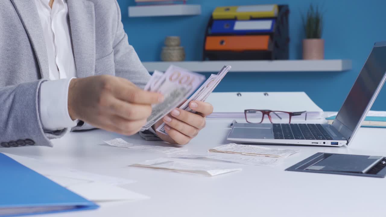 Businessman calculating high priced invoices, receipts and planning budget in office.