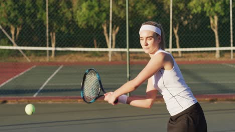 Video-of-happy-caucasian-female-tennis-player-holding-racket-and-hitting-ball