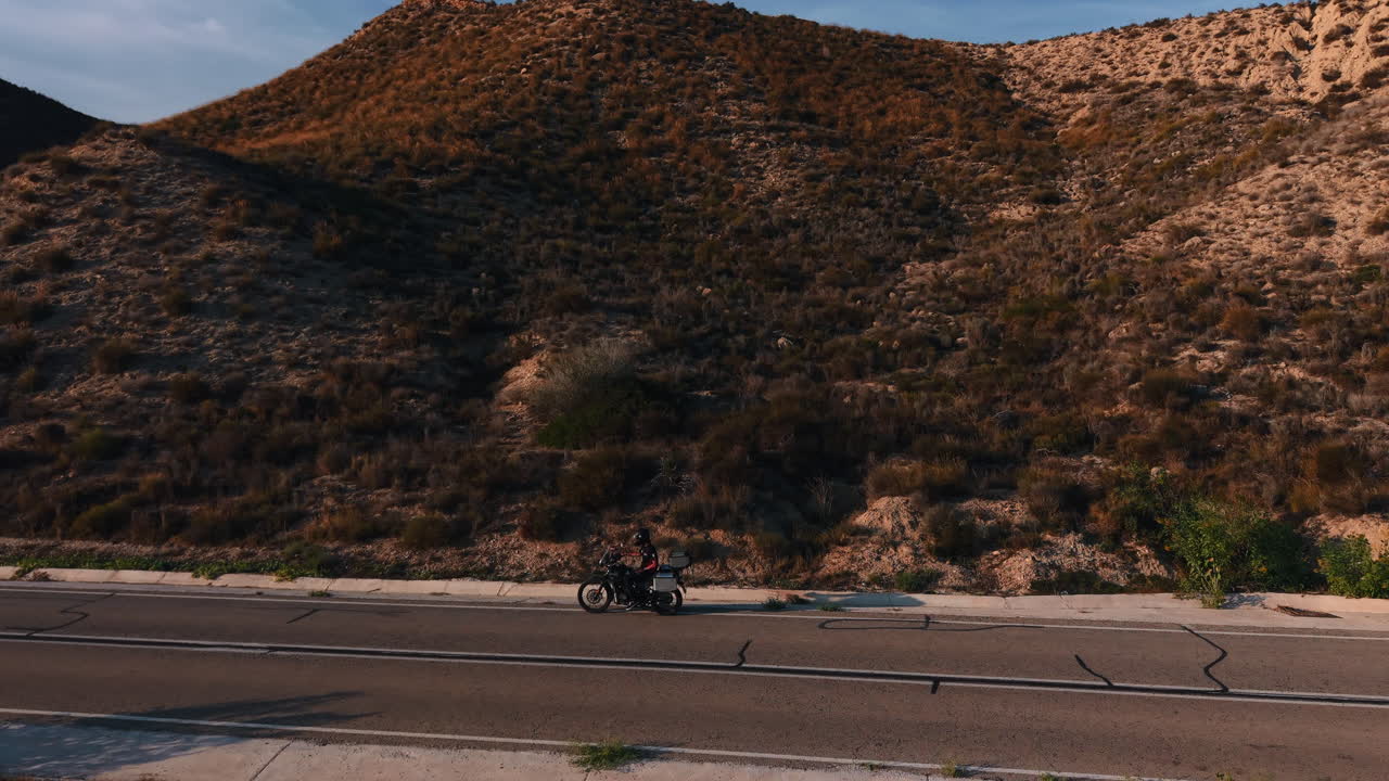 Motociclista che guida lungo una strada di montagna