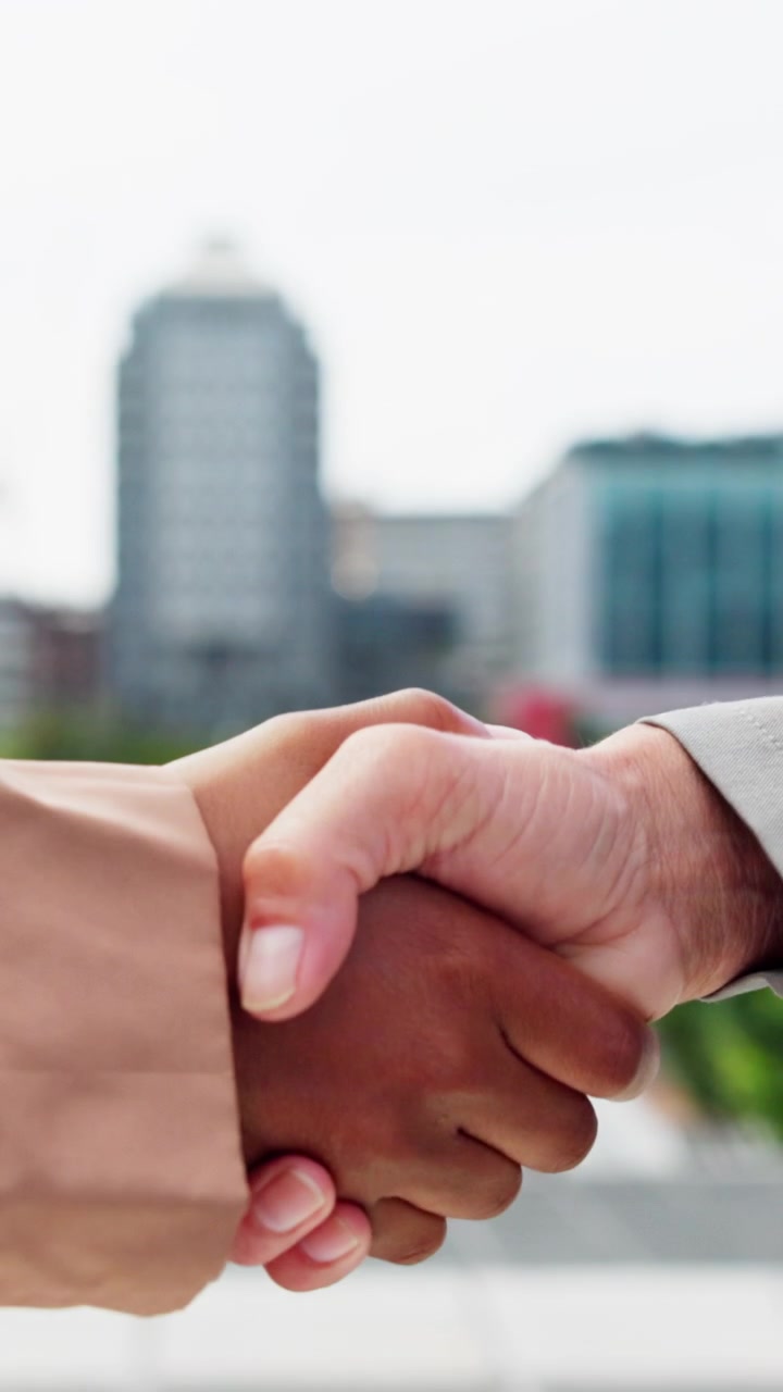 Professionisti che si stringono la mano all'aperto in ambiente cittadino