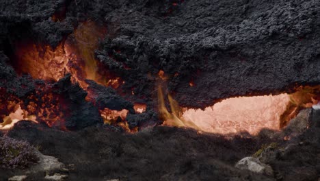 primer plano de lava derretida que fluye lentamente desde el volcán grindavik en el cráter sundhnúkur, islandia