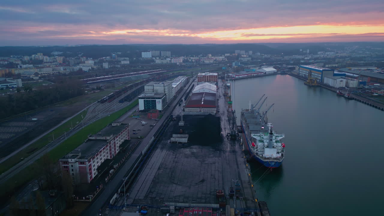 Aerial view of a harbor with cargo ship at sunset