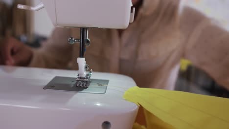 mujer de raza mixta cosiendo en una oficina de moda