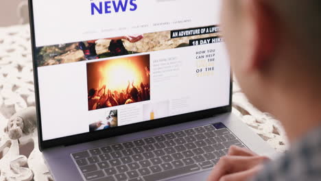 person browsing a laptop with news website