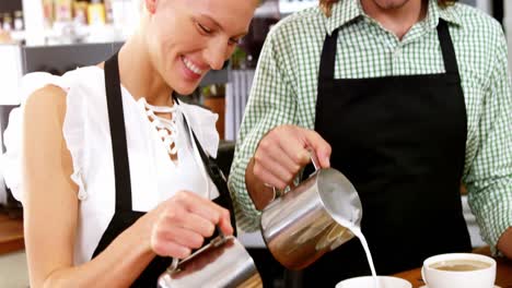 Lächelnder-Kellner-Und-Kellnerin,-Die-An-Der-Theke-Eine-Tasse-Kaffee-Zubereiten