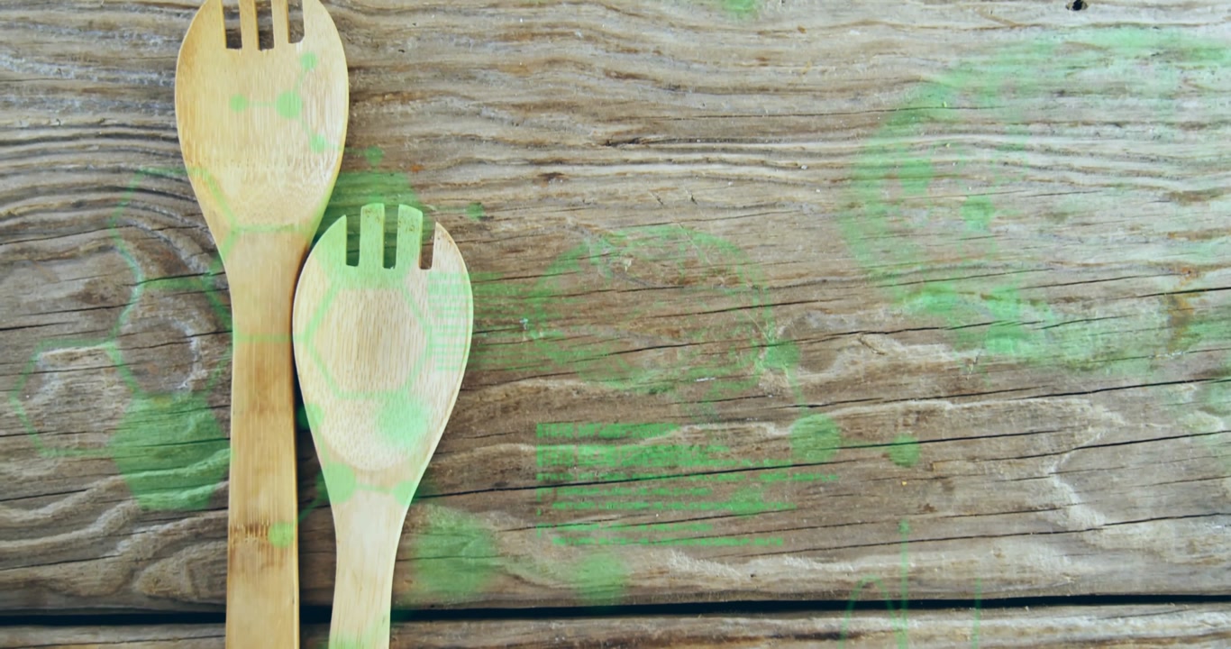 On start wooden spatula and slotted spoon rising revealing heads with green bokeh showcasing rustic