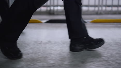 Special-forces-squad-moving-on-bridge.-Men-in-black-shoes-walking-on-road