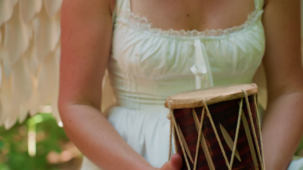 Close up of magical creature holding traditional drum on forest log, warm sunlight illuminating polished wood and rope texture, symbolizing ancient rhythm, serenity, and spiritual connection with nature