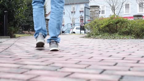 Hombre-Caminando-Lentamente-Sobre-Un-Camino-Pavimentado-De-Piedra