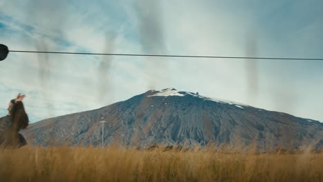 a cute girl with long hair ziplines in front of a mountain scape