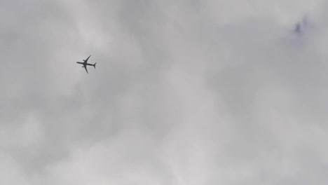 vertical video of looking up to the sky as an airplane flies by