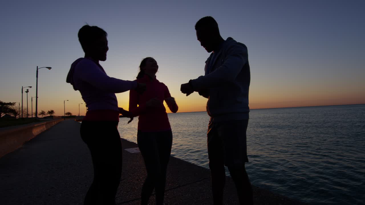 해가 지는 실루 다민족 친구들이 호수 에서 휴식을 취하고 있습니다.