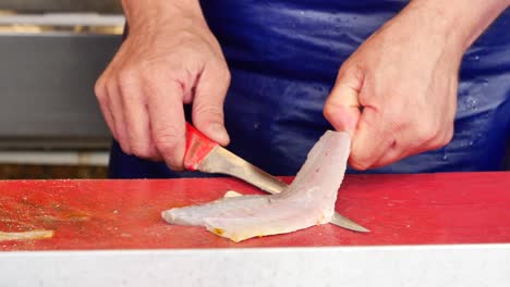 a man filleting a fish at a market