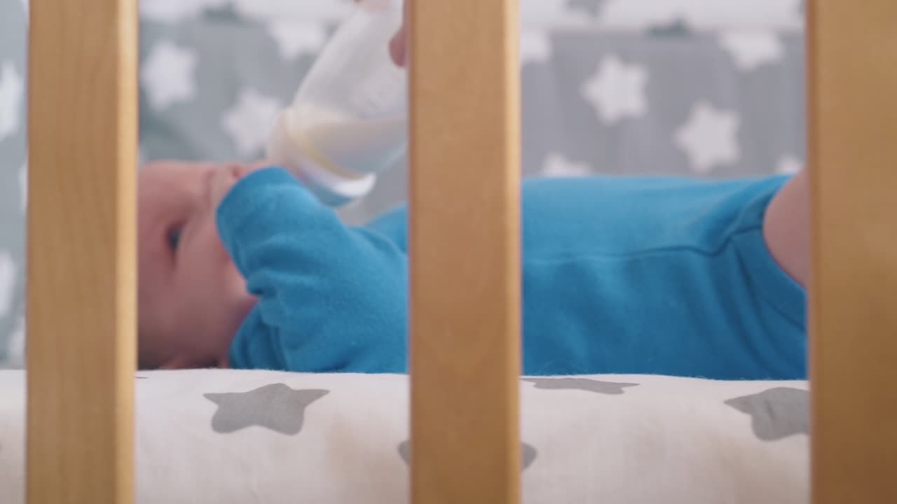 la mamma nutre un bambino carino con un delizioso mix di latte in una culla moderna