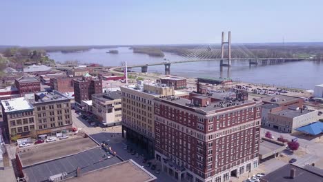 Toma-Aérea-Ascendente-Sobre-La-Pequeña-Ciudad-De-América-Burlington-Iowa-Downtown-Con-El-Río-Mississippi-Antecedentes-2