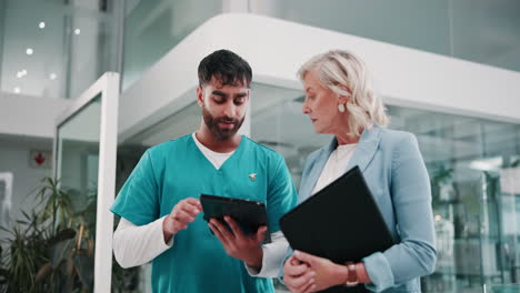 a doctor and a patient discuss medical records on a tablet.